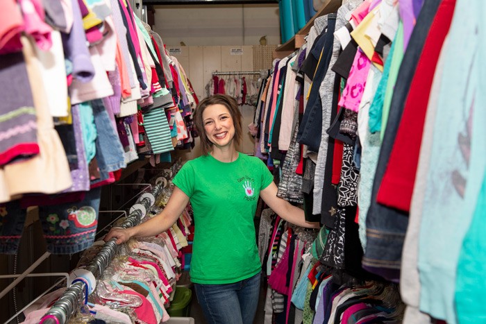 Amy Van stands among racks full of donated clothing