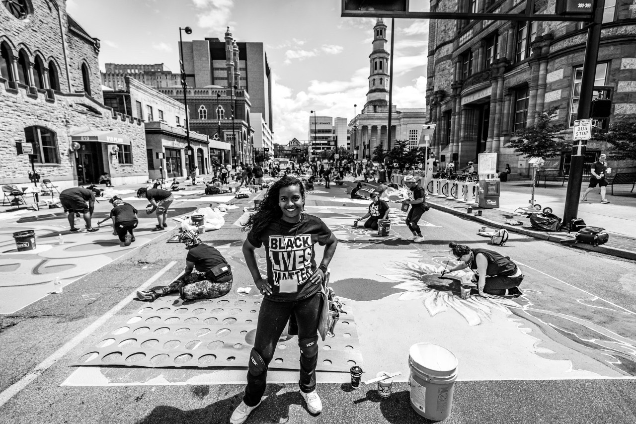 Adoria Maxberry stands in front of Black Lives Matter mural in Cincinnati.