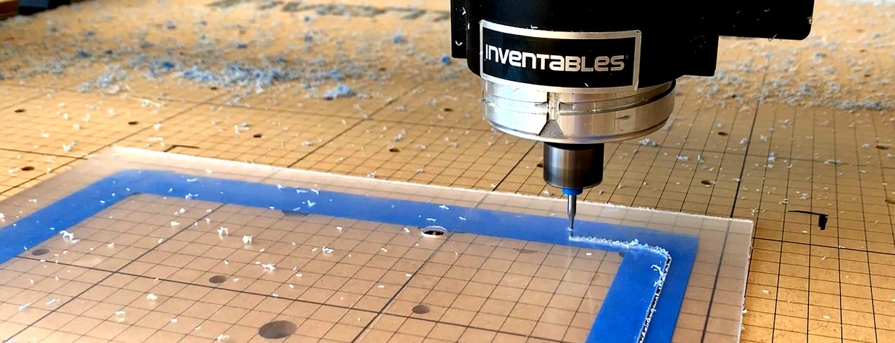 A machine cuts out plastic to create a face shield