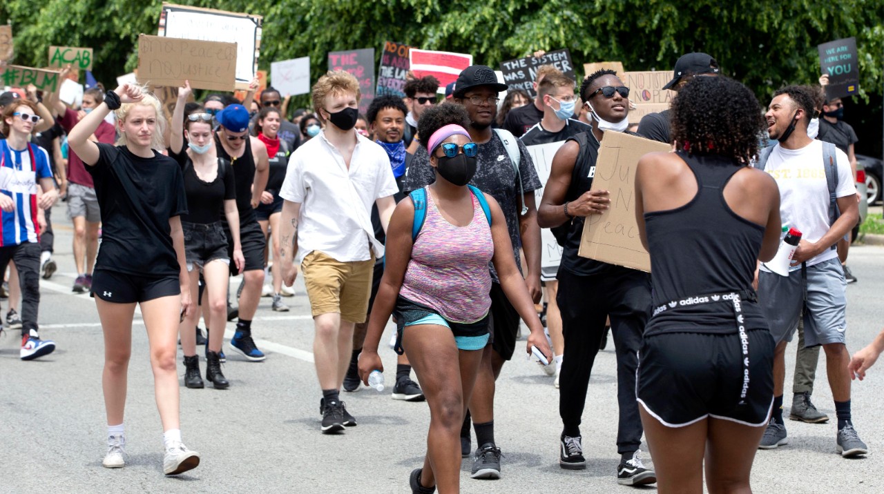 people walk down the street during a protest