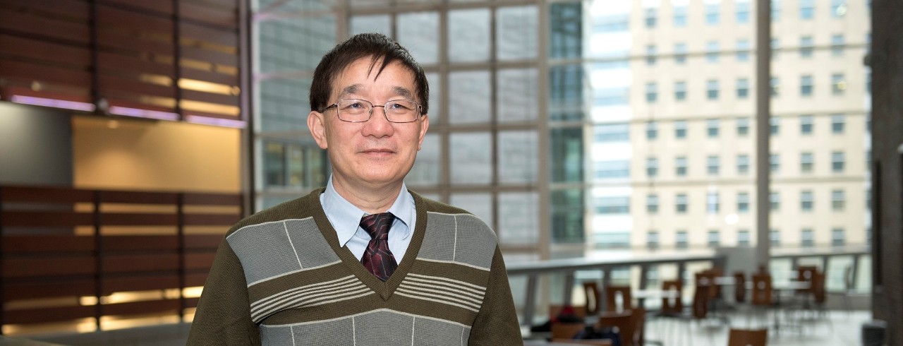 Professor Bingfang Yan standing on the bridge inside the CARE/Crawley building.