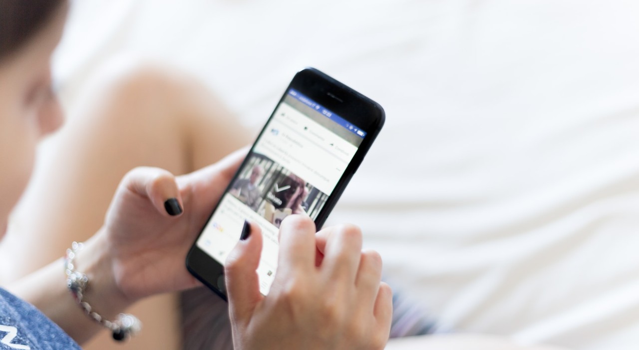 cell phone user scrolling through social media
