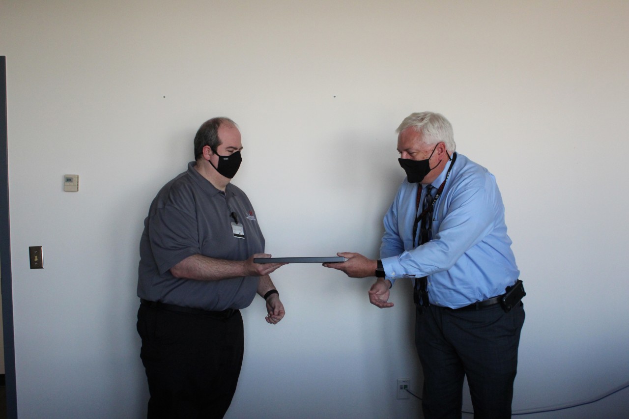UC Public Safety Director James Whalen presents the Rave Mobile Safety SmartSave Award to Emergency Communications Dispatcher Ted Langdon.