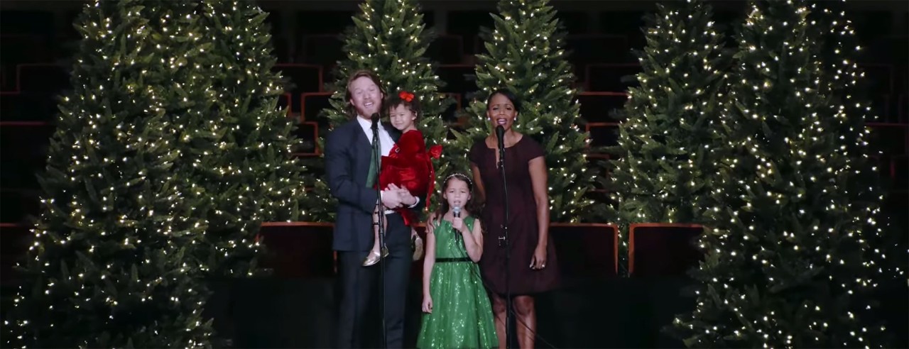 A family performs on stage during a holiday concert