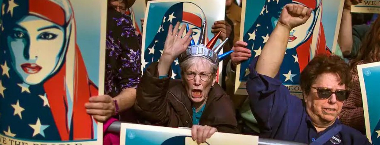 Protesters hold up fists and hold signs