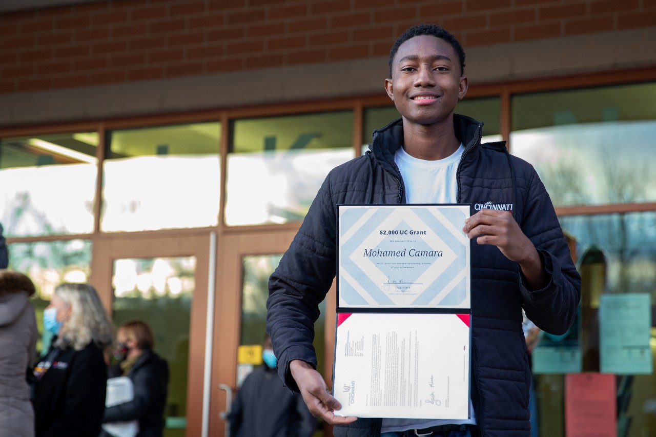 Members of the UC community, including Jack Miner and the Bearcat, surprise Mohamed Camara to congratulate him on his admission to UC.
