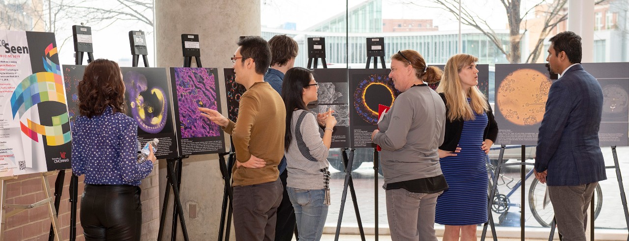 People at a 2018 Internal Medicine Research Symposium viewing medical photos