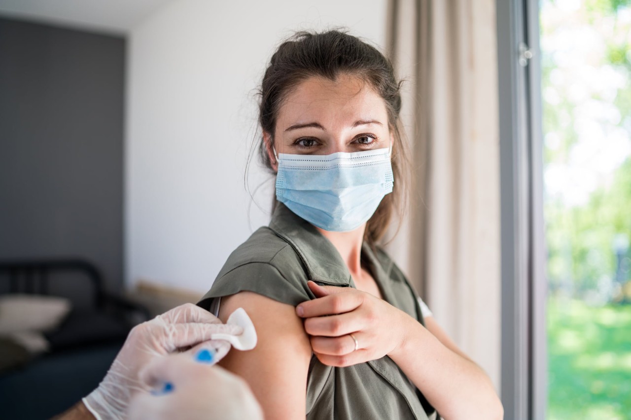a woman wearing a face covering getting a vaccine