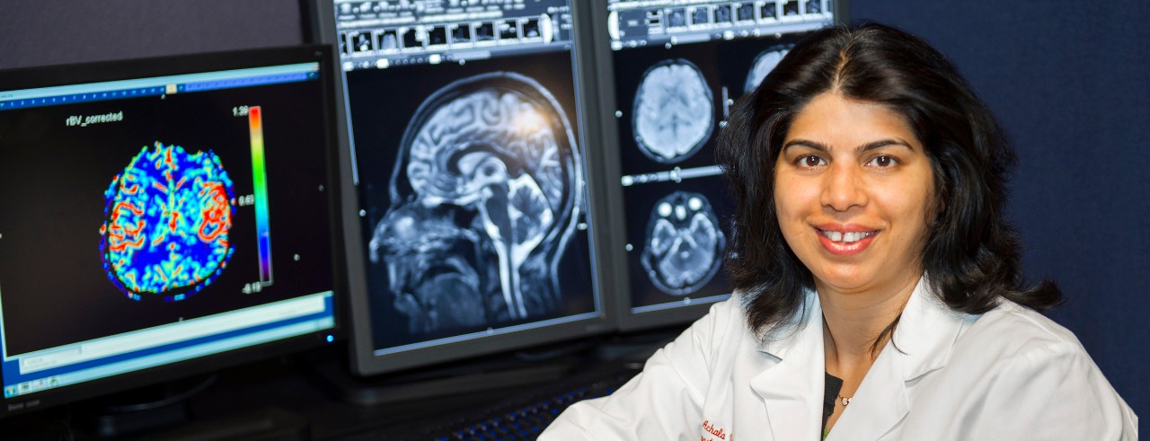 Fr. Achala Vagal in front of monitors