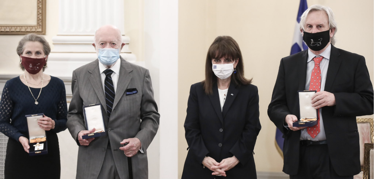 Sharon Stocker and Jack Davis stand alongside Greek President Katerina Sakellaropoulou and fellow honoree Charles Williams with their medals.