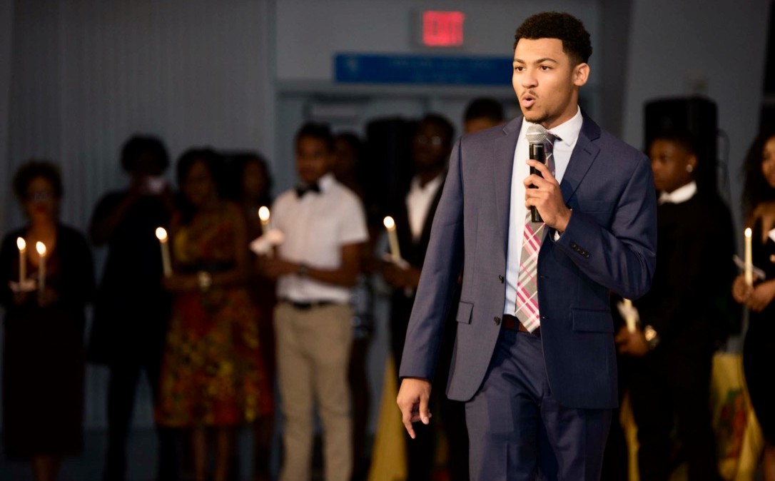 UC's Chandler Rankin holding a mic in front of a crowd.