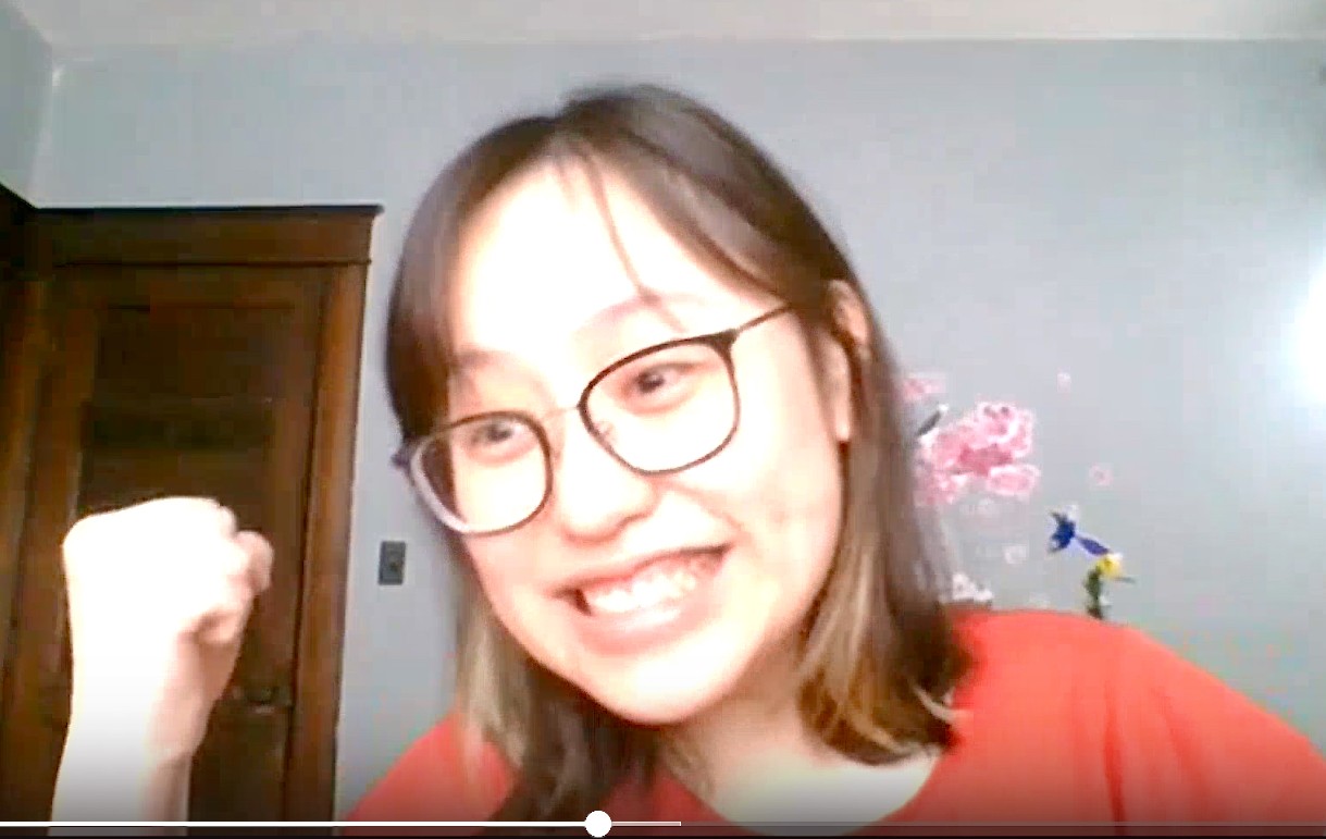 UC student My Dinh smiles with her fist in the air from happiness.