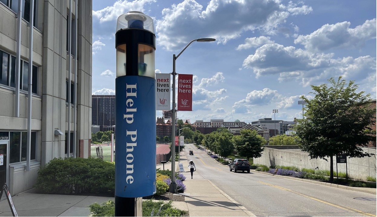 One of UC's Help Phones on a pole in front of a campus building.