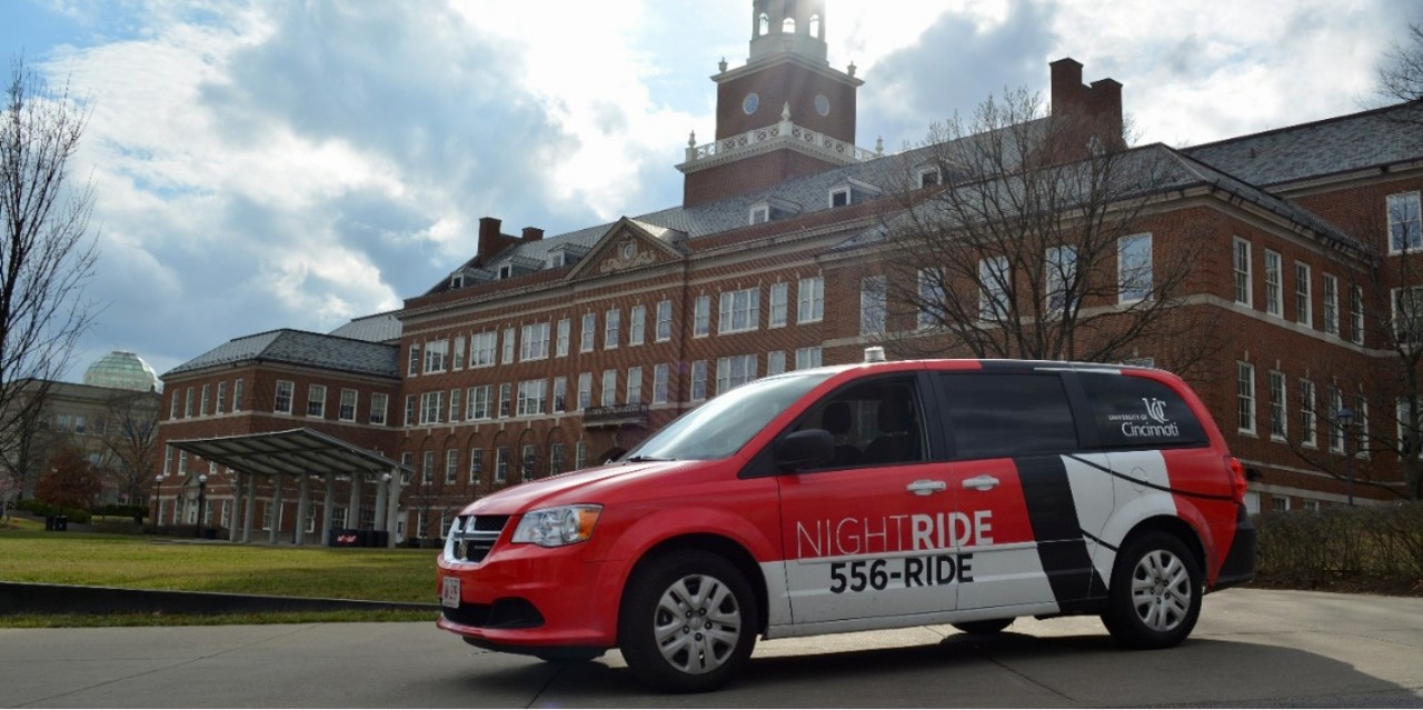 UC's red and white NightRide van in front of McMicken Hall.