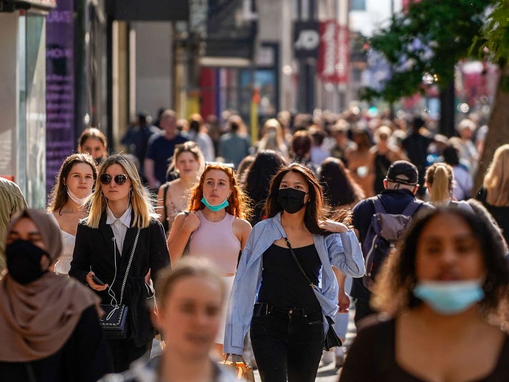 Photo shows people walking on a city sidewalk