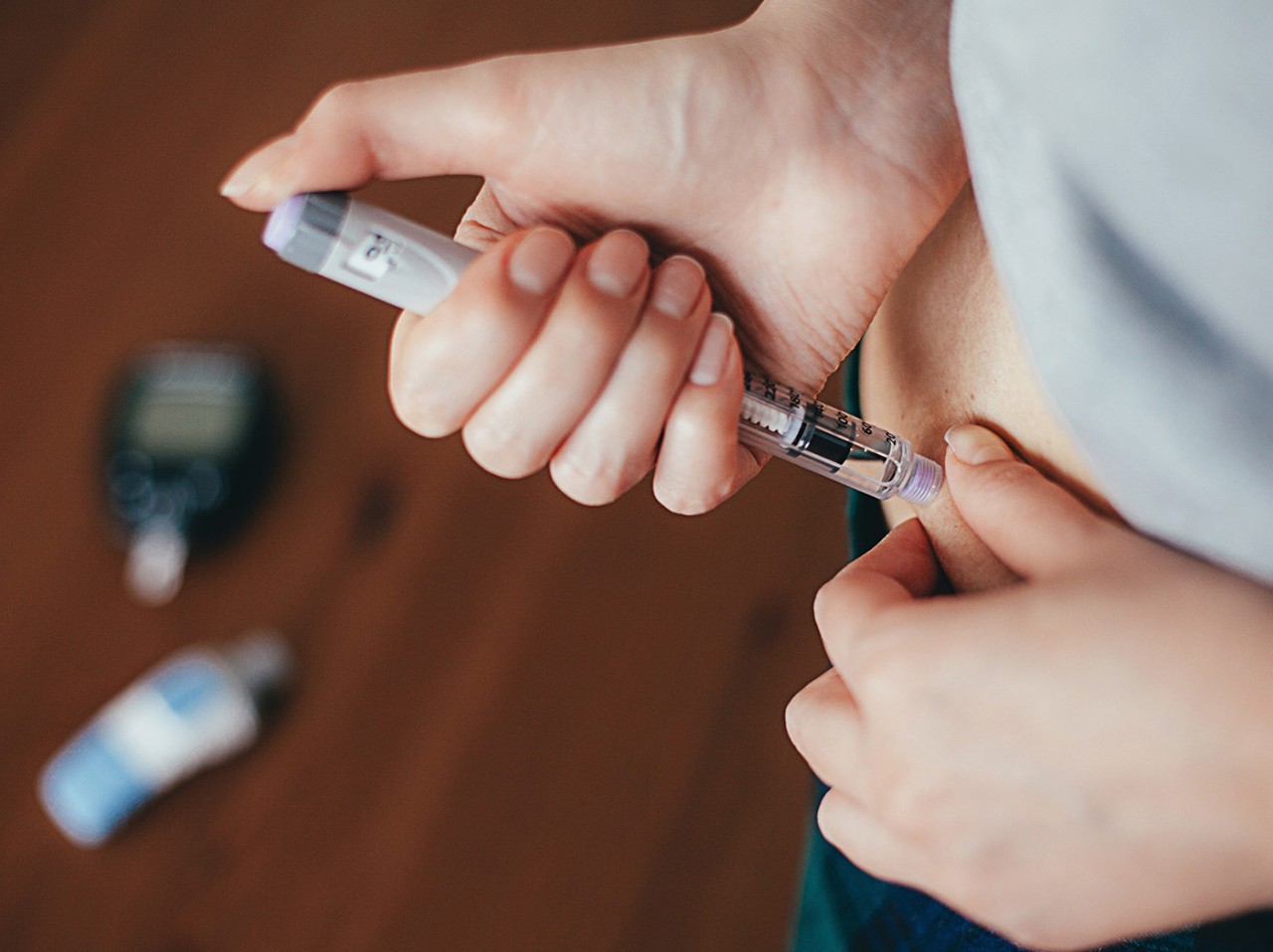 a woman injects herself in the abdomen with liraglutide