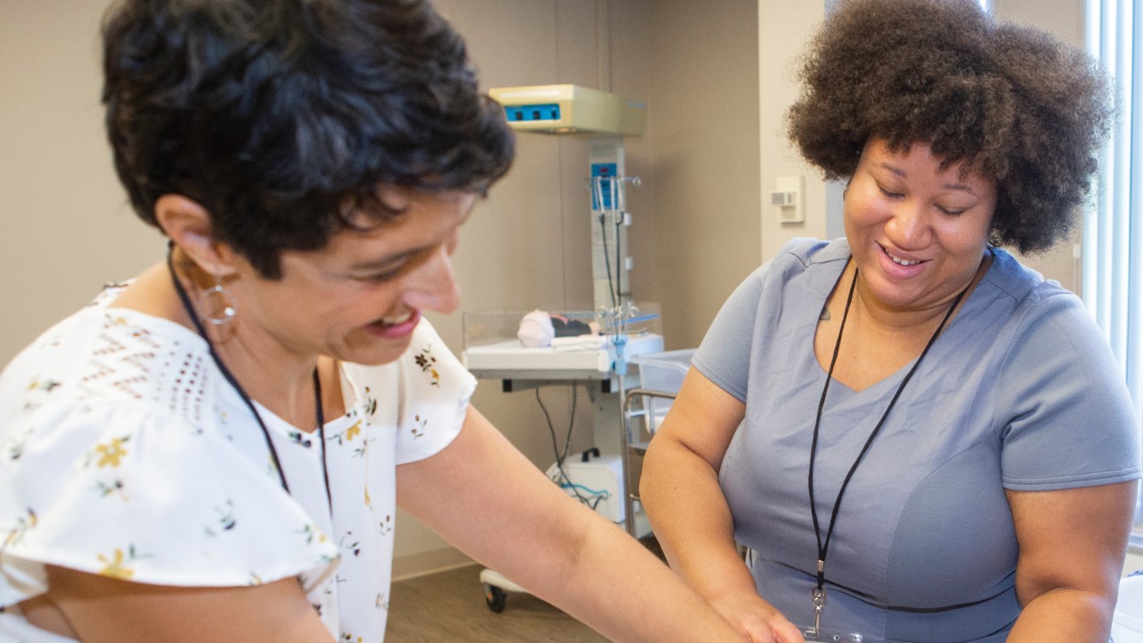 Two women with manequin mom and baby