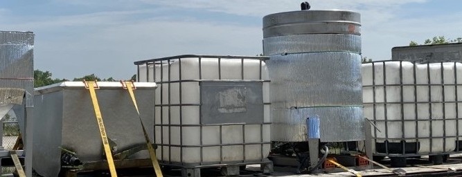 a series of large metal containers lined up on a flatbed truck