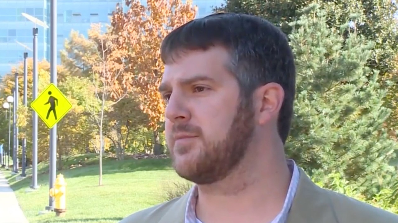 Man stands outside during a television interview.