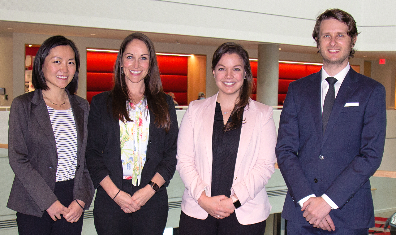 Three women and a man pose for a picture.