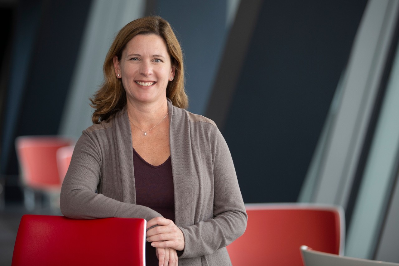 a woman smiles while looking at the camera