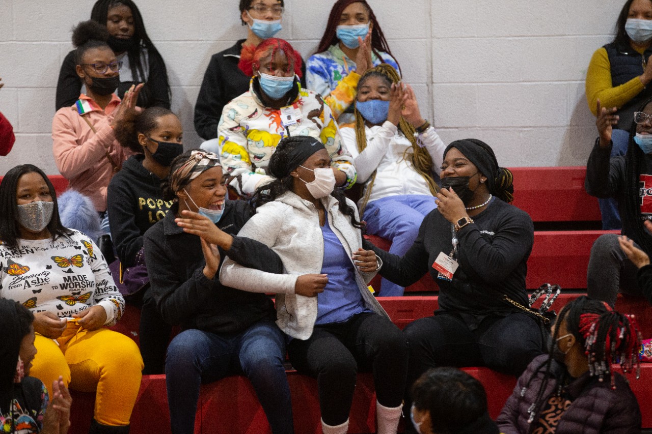 A group of excited students in a school gym's stands
