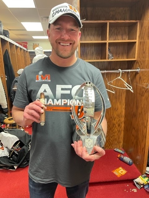 Dan Willen, assistant head athletic trainer for the Cincinnati Bengals holding a trophy in the Bengals locker room