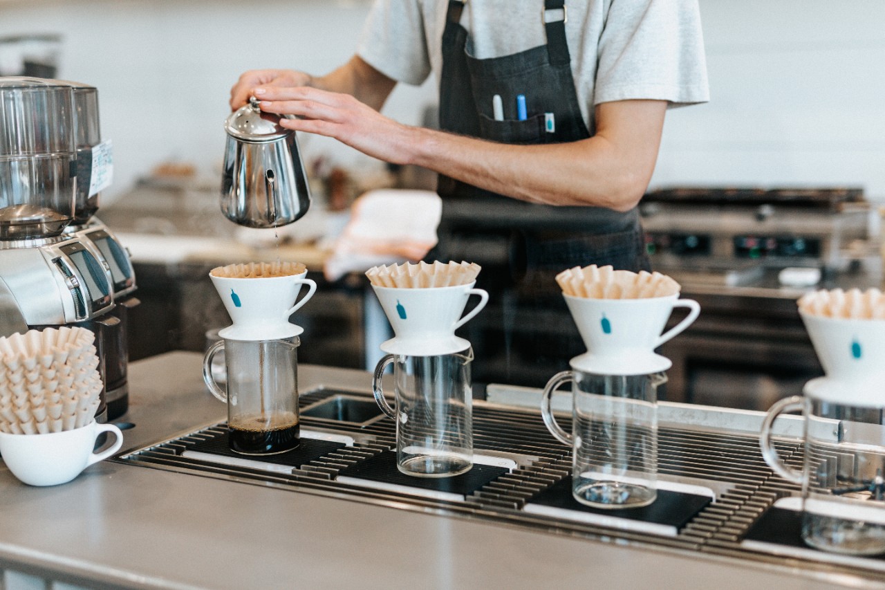 A barista pours coffee at a coffee shop