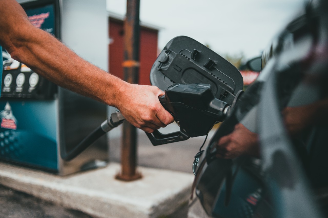 A person fills a car's gas tank.