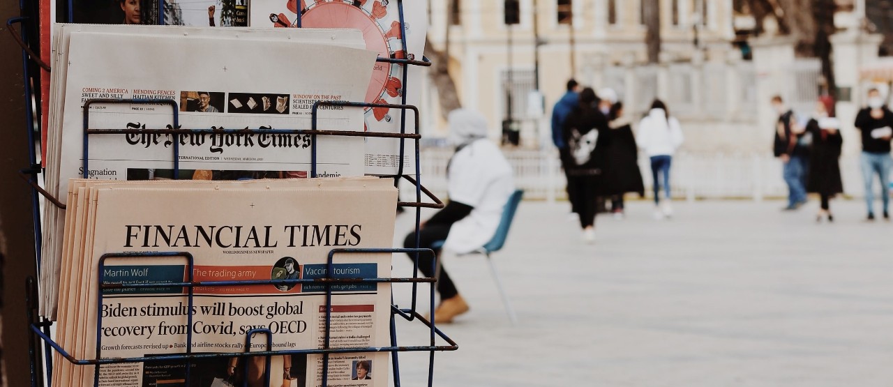 newspaper stand with people walking in the city