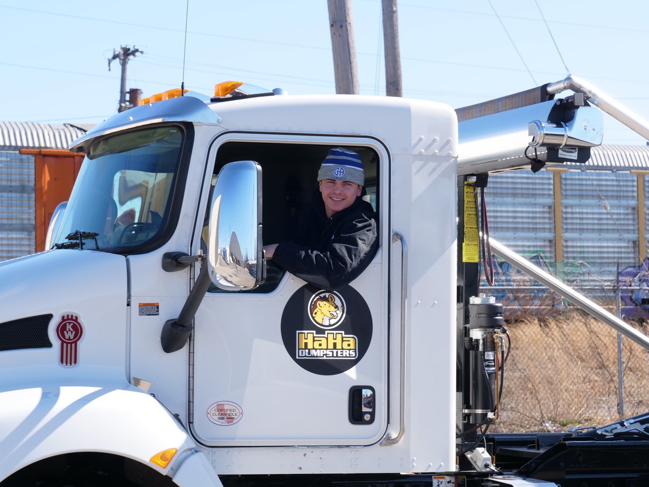 A young business owner drives one of his dumpster trucks.