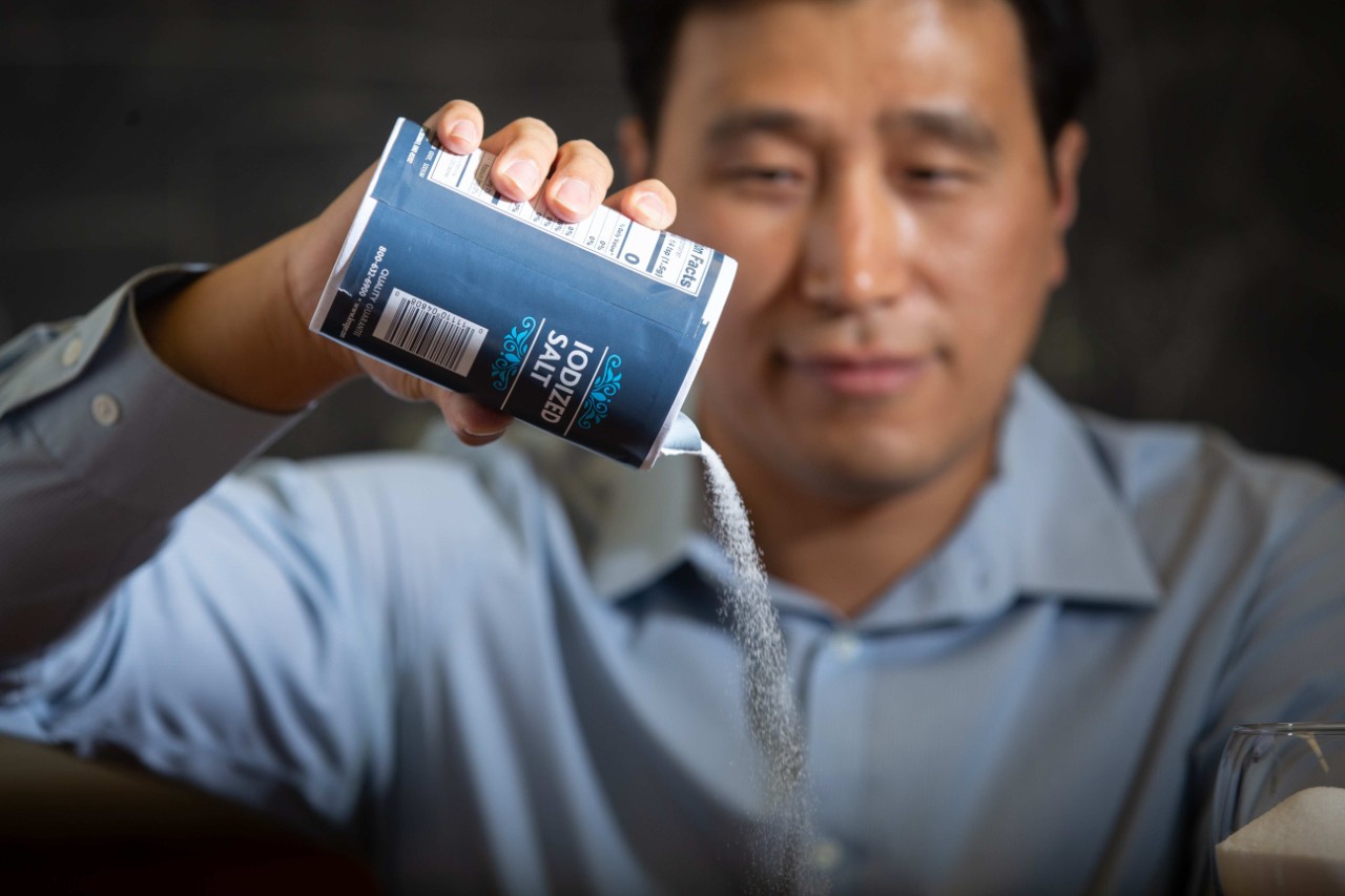 Yu Shi pours salt out of a container.