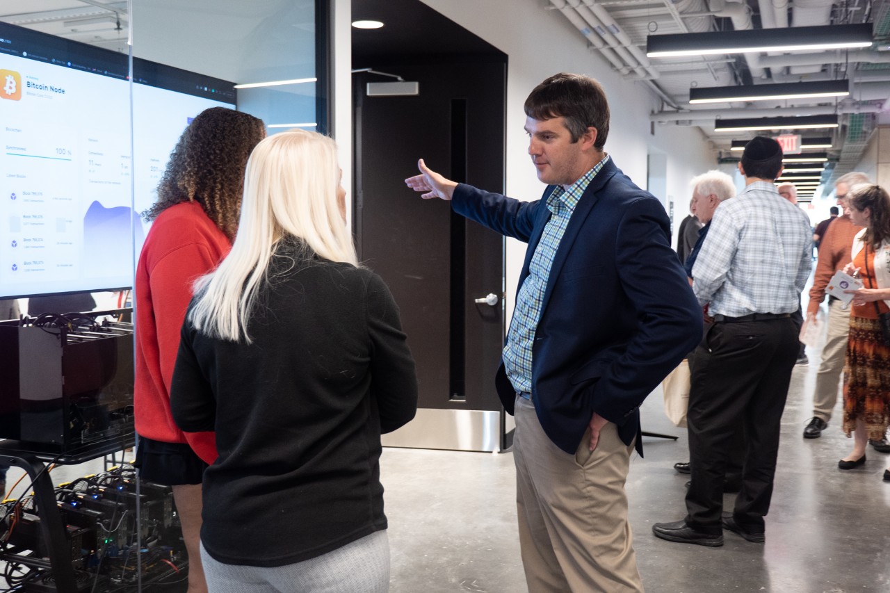 Michael Jones greets guests to the Cryptoeconomics Lab during the grand opening of UC Digital Futures. 