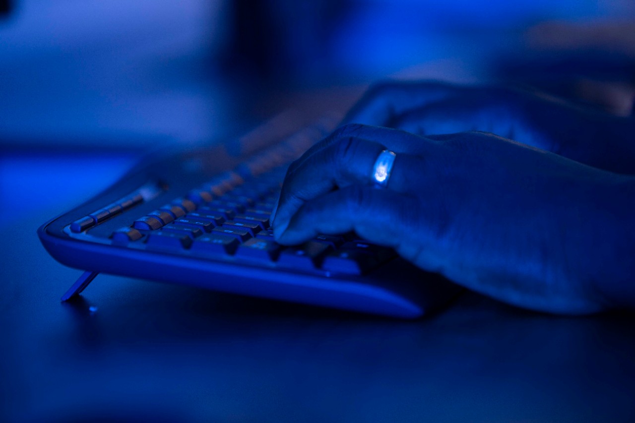 dark photo with hands on a keyboard