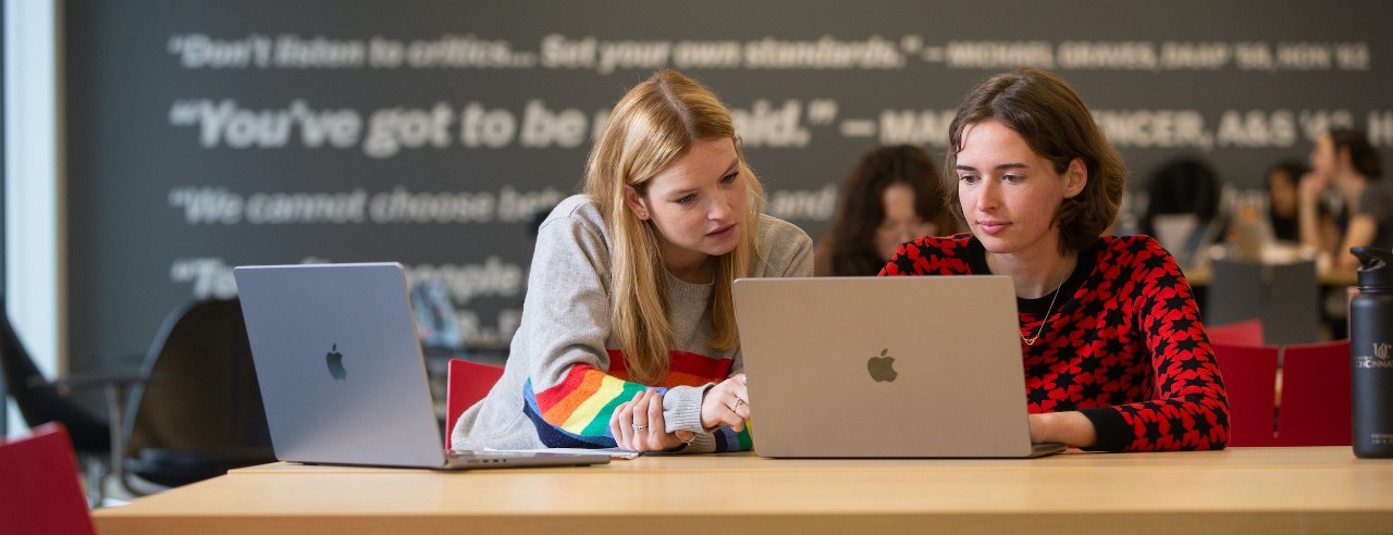 Two UC students work on computers to organize their college search