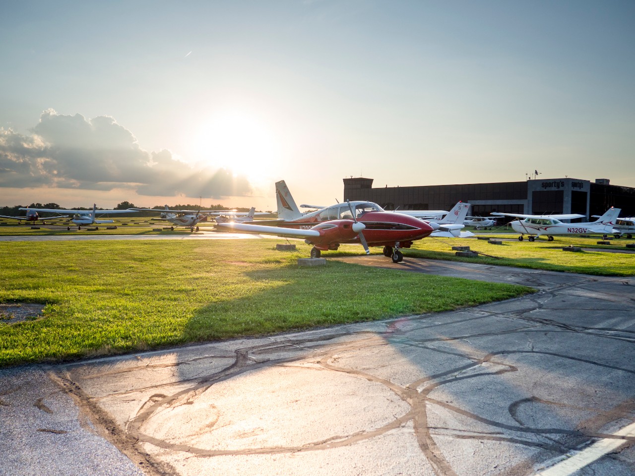 UC plane in front of Sporty's Academy building at sunset