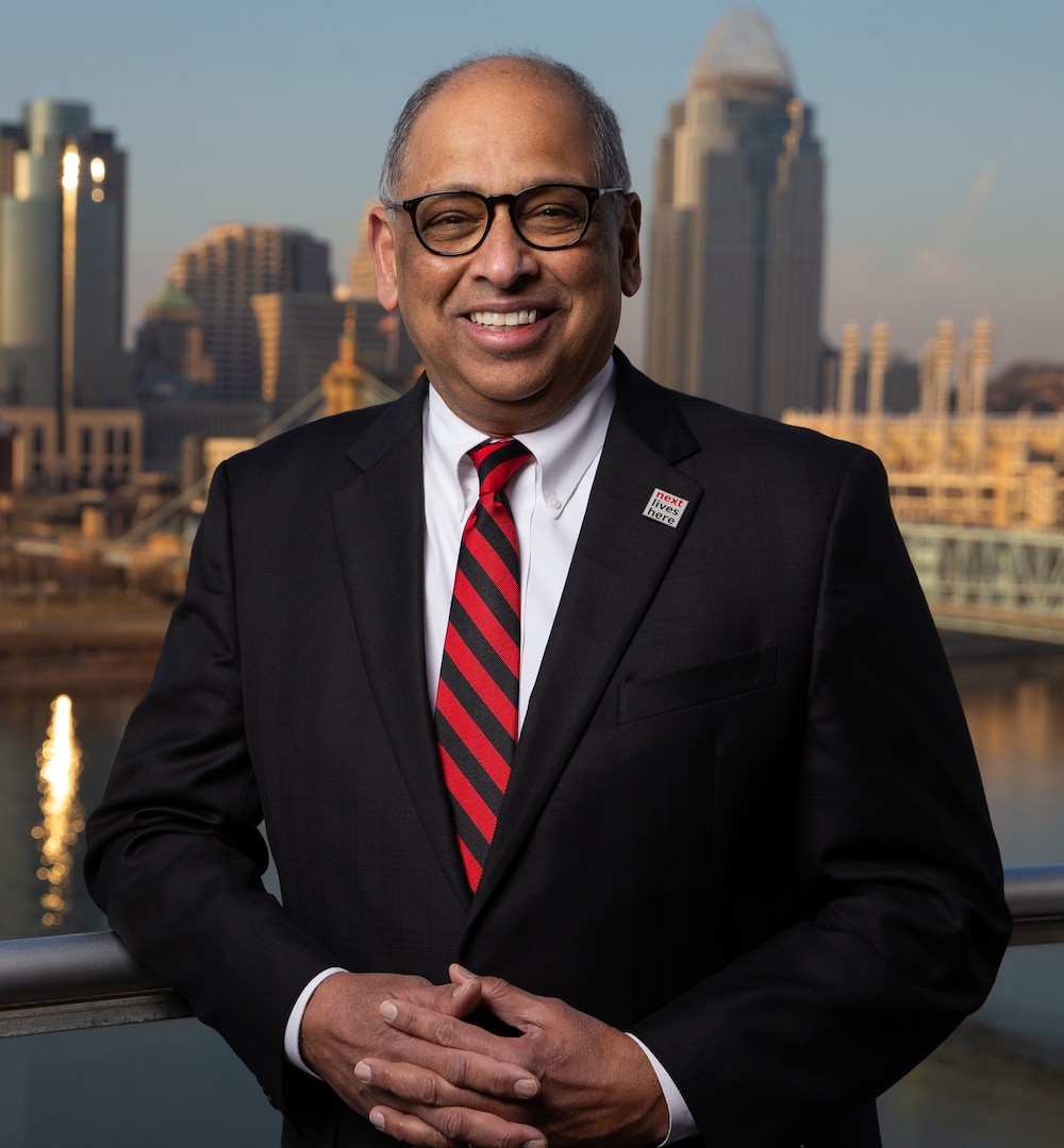 UC President Neville Pinto portrait in front of Cincinnati skyline