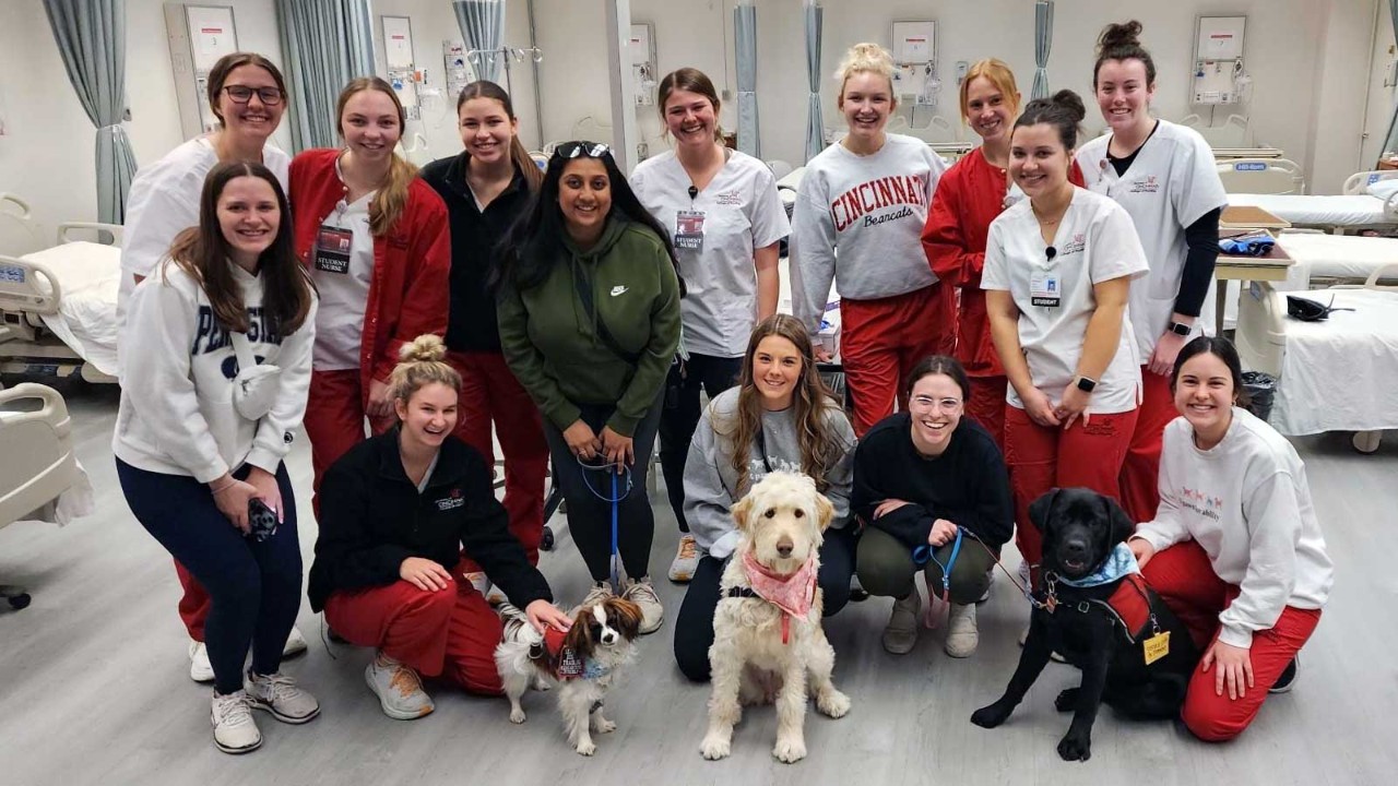 Simulation event in University of Cincinnati College of Nursing's simulation lab with students and 4 Paws for Ability volunteers
