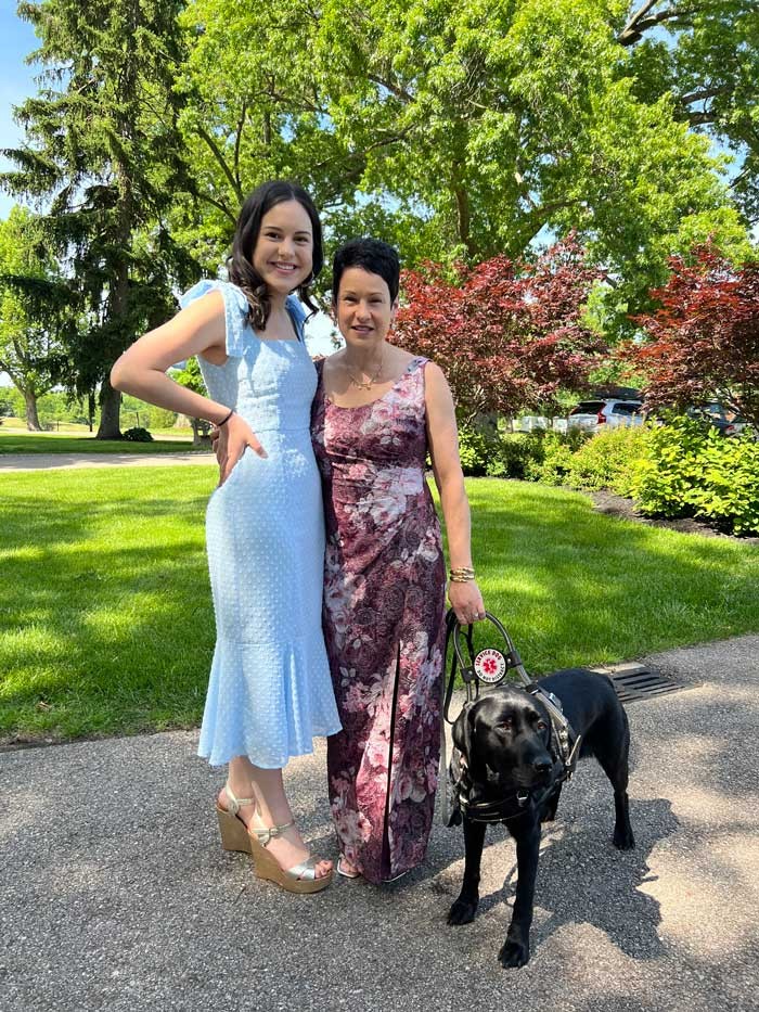 UC College of Nursing graduate Megan Peterson with mother and Scarlett, Megan's mother's service dog