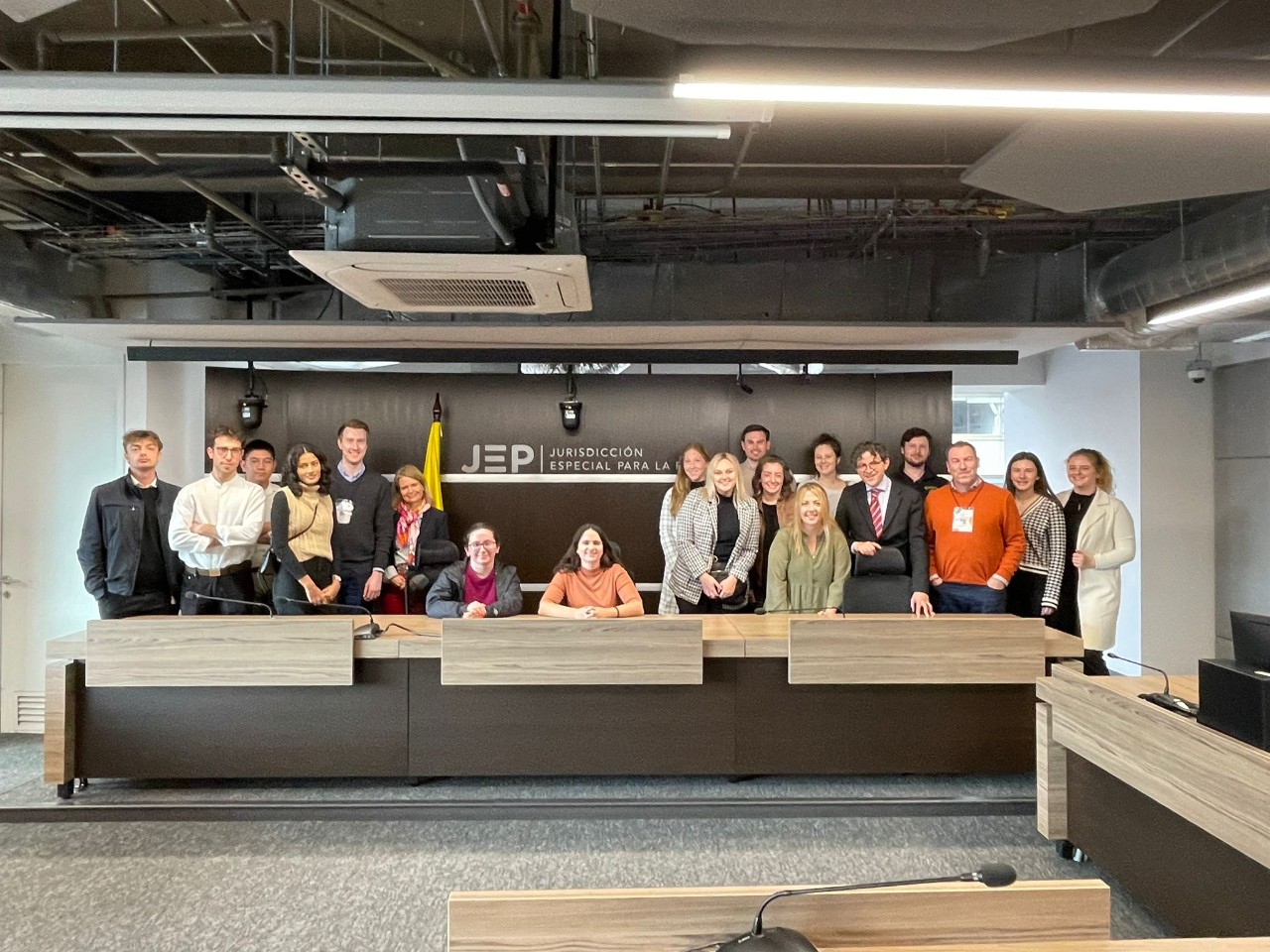 A group of students stands behind a desk at the Special Jurisdiction for Peace.