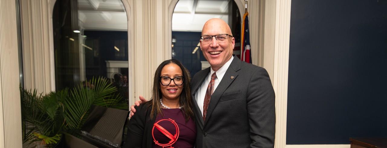 Gloria Samuel (left) and Dean John Weidner (right) pose with the alumni award trophy. 