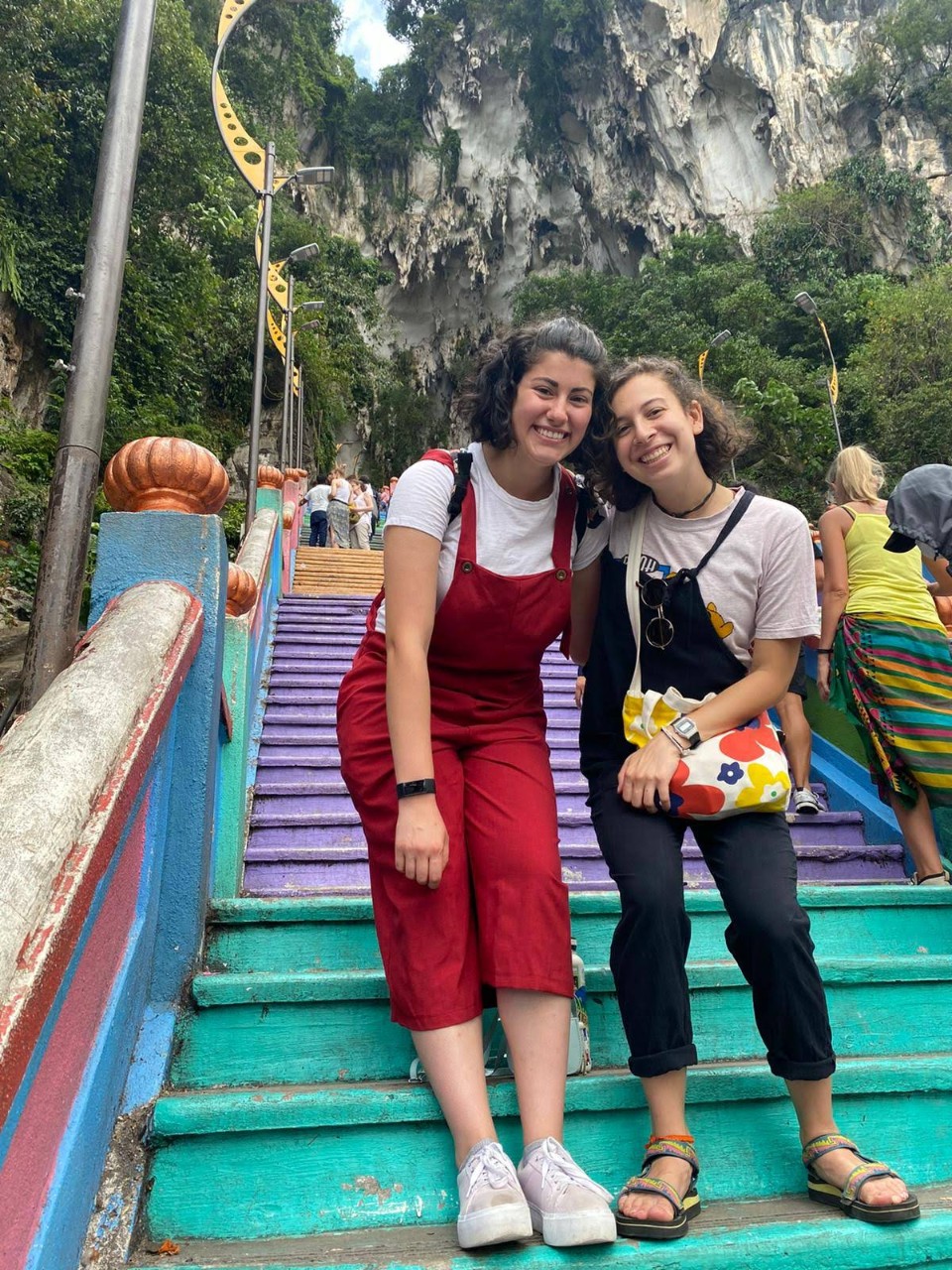 Two women pose while standing on a set of colorful steps in Chiang Mai, Thailand.