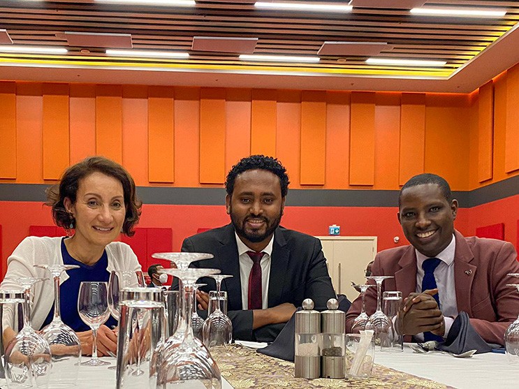 Kerr, Meshesha and Muvunyi sit at a banquet table