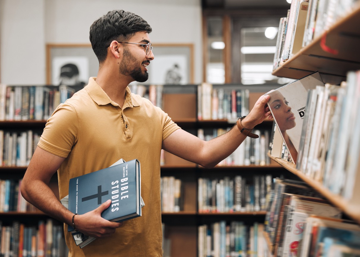 Student with bible in the library to study
