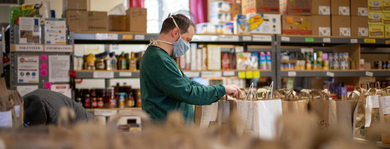 A person prepares bags of food at a food pantry