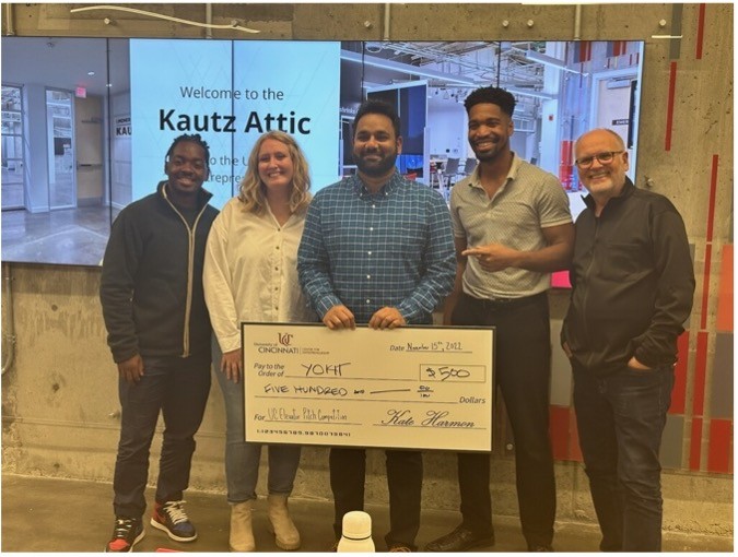 Sai Bonthu holds a giant check upon winning third in UC's elevator pitch competition
