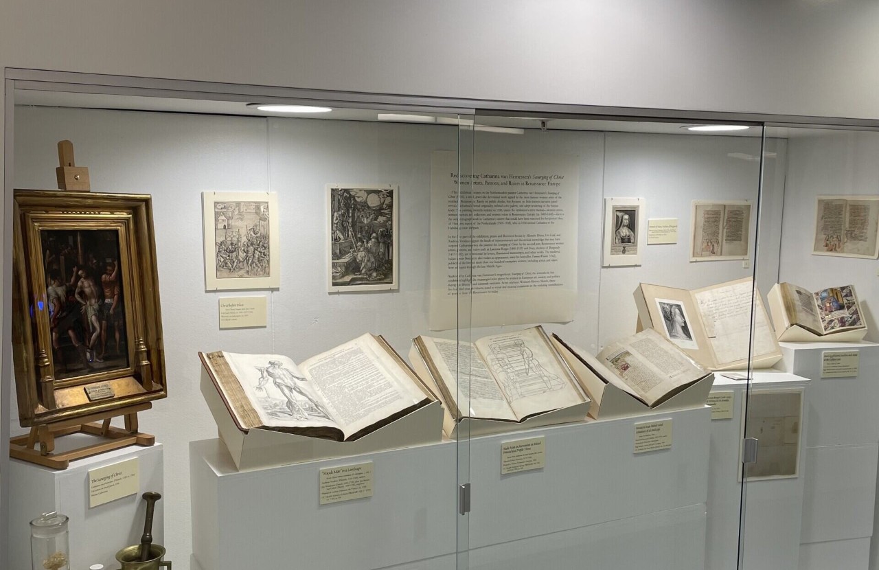 glass case with painting and books on display