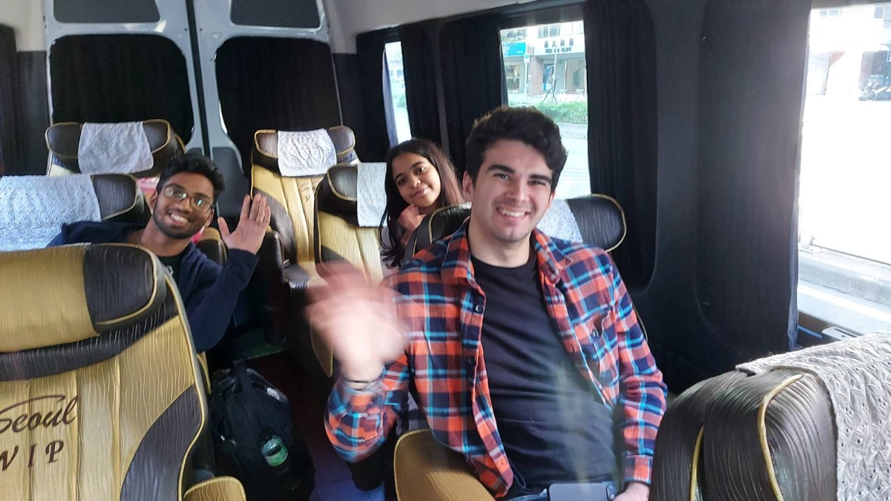 Students smile and wave on a bus in Taiwan
