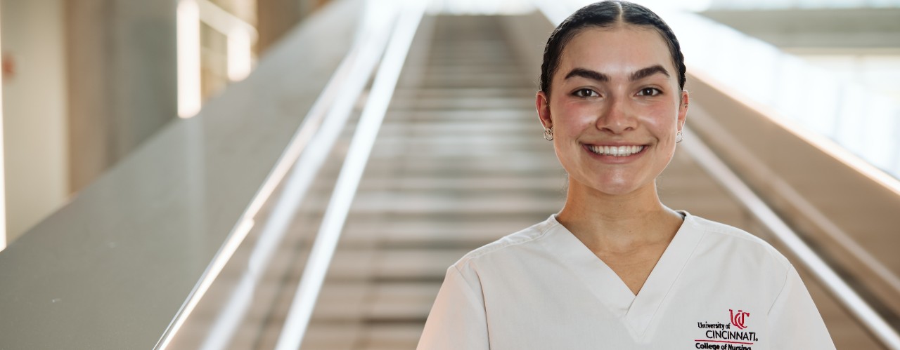 UC nursing student Grace Hall smiles standing inside UC's College of Nursing.