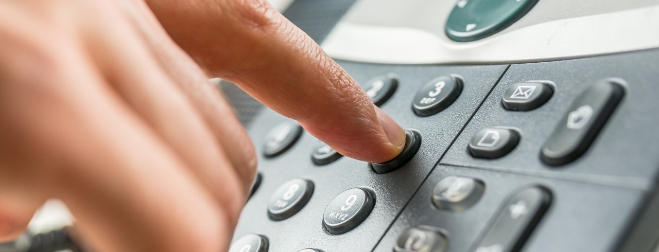 Closeup of male hand dialing a phone number making a business or personal phone call.